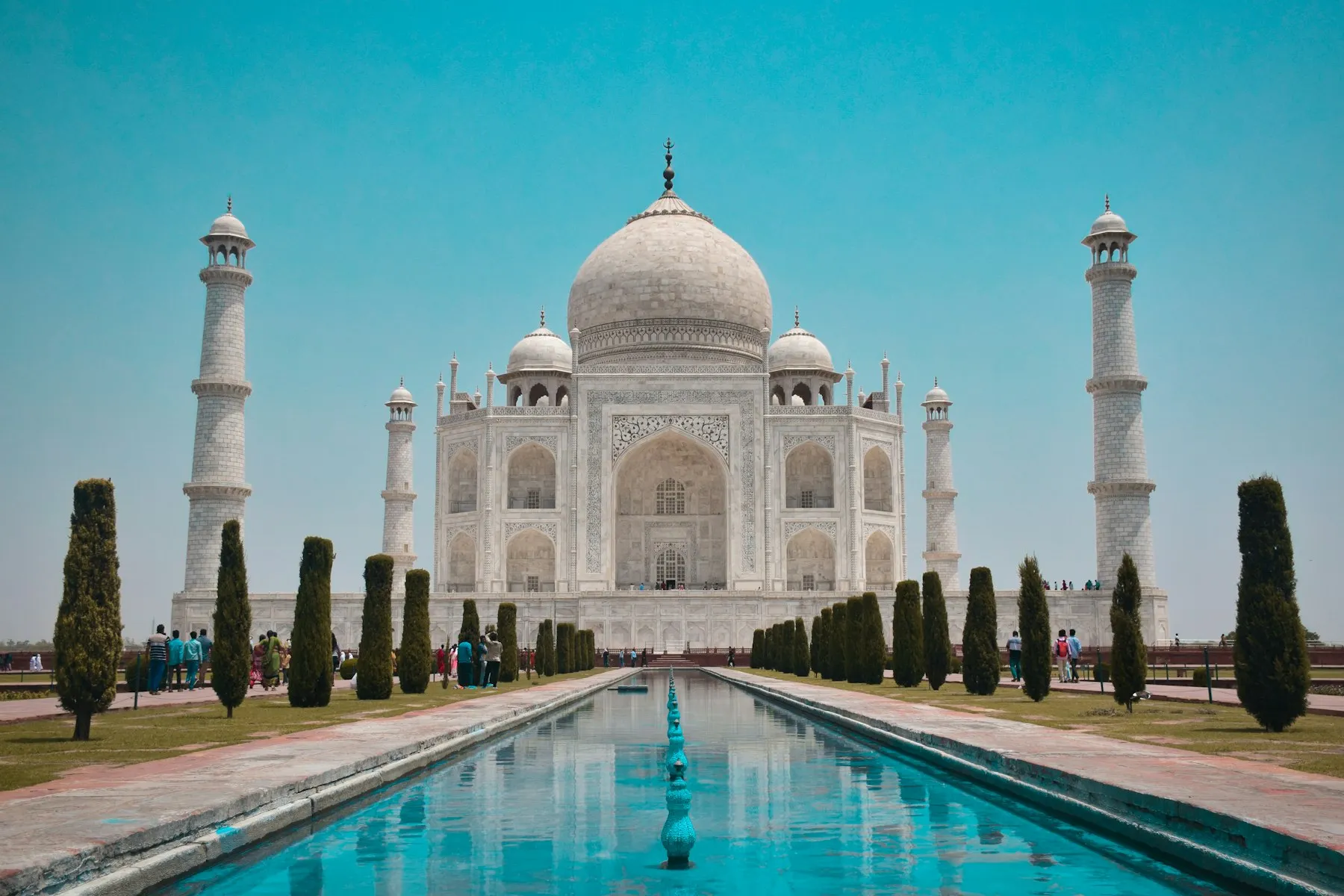 The white marble Taj Mahal reflected in its long water channel at dawn