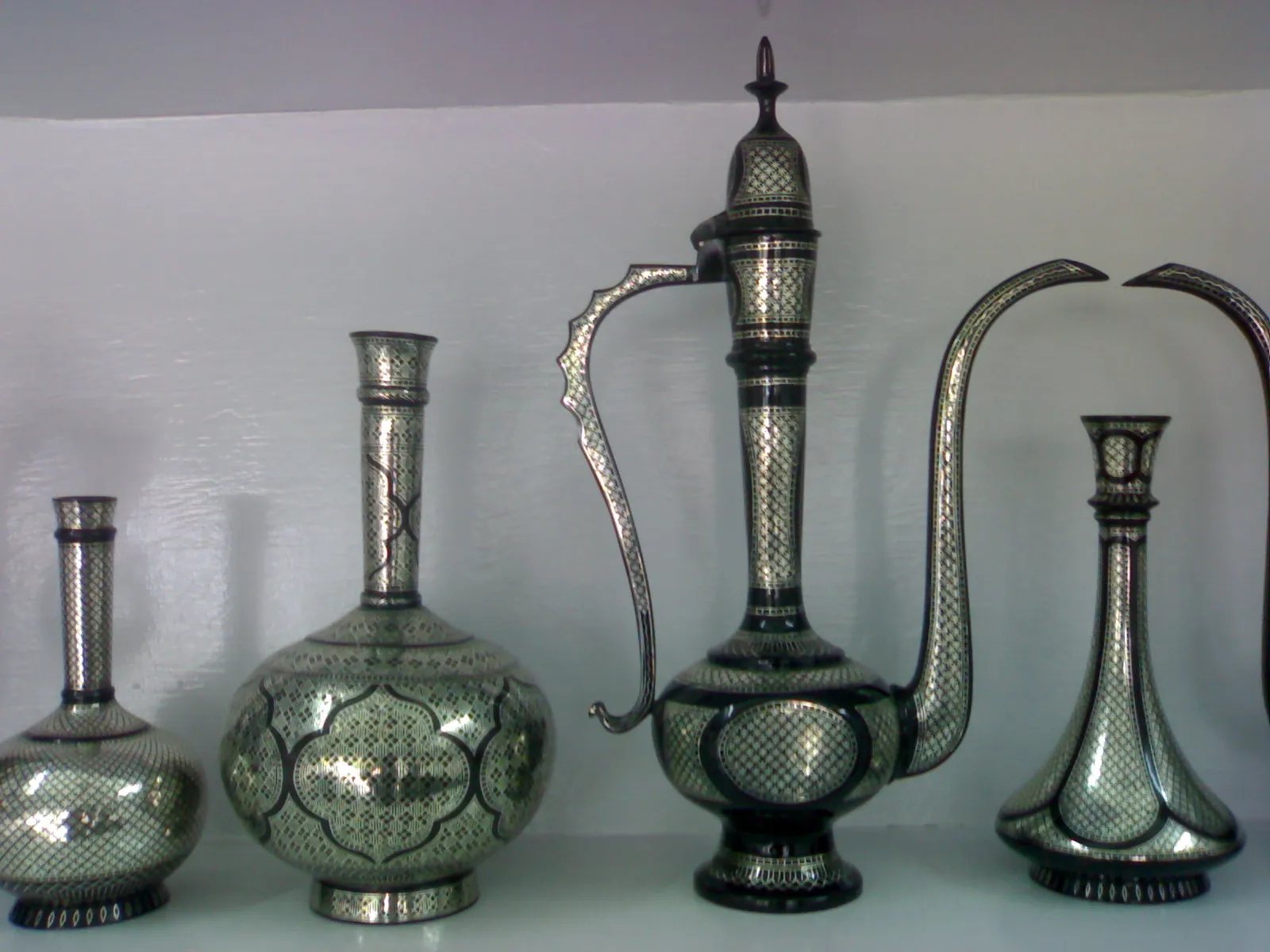 Bidriware vases and a decanter with fine silver inlay on a blackened alloy body