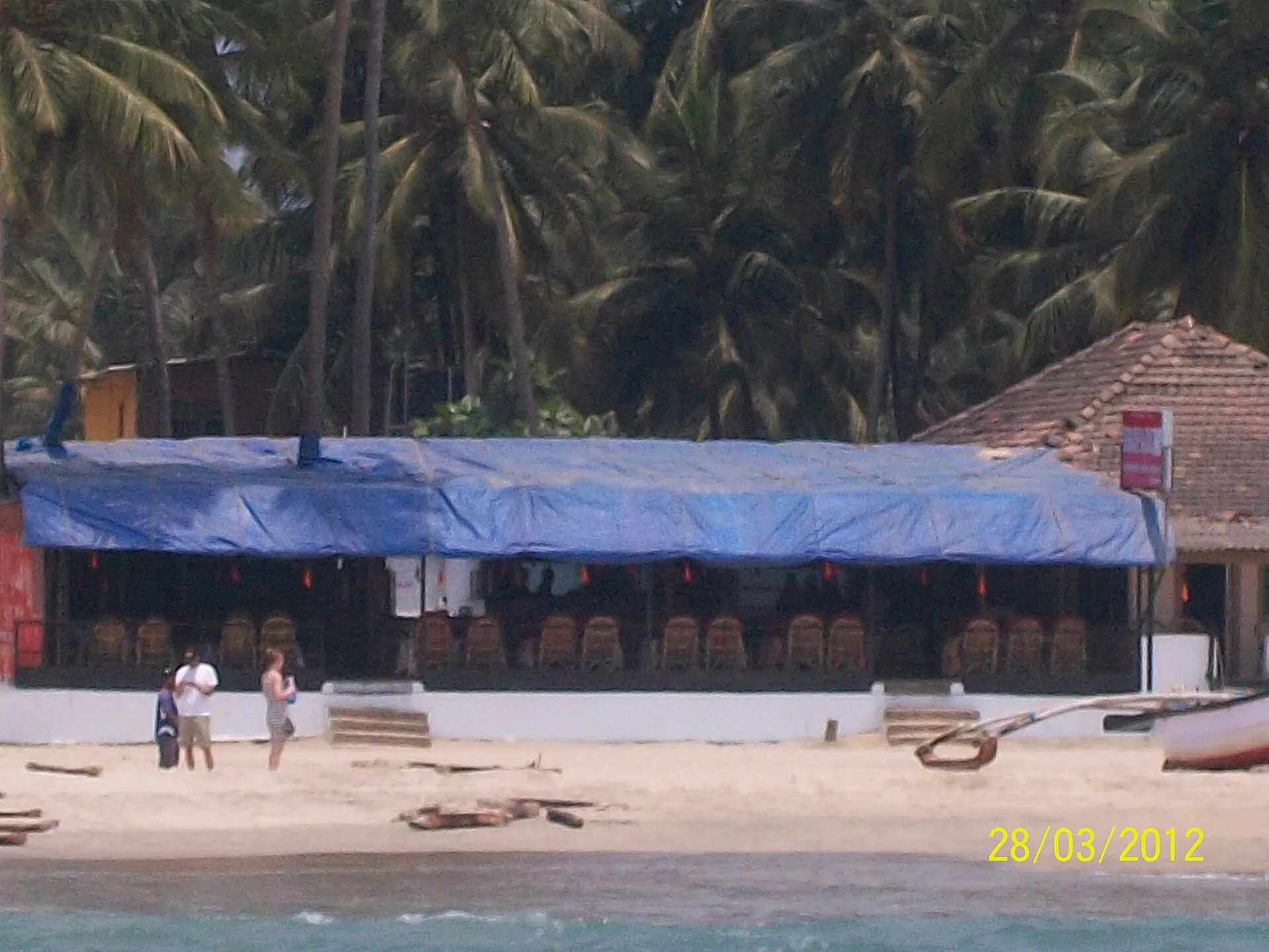 Rocky headland and palm trees framing Palolem Beach in south Goa