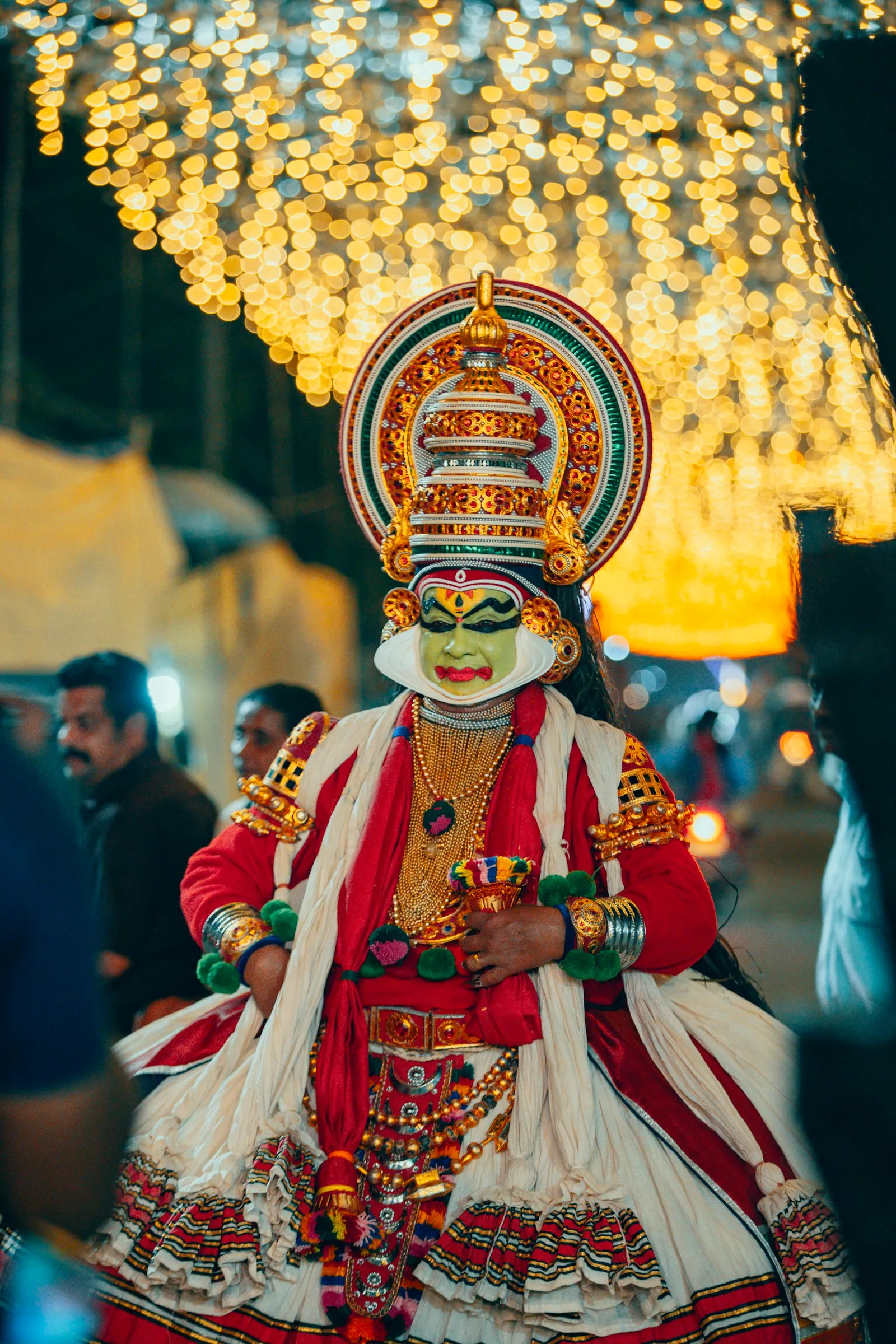A Kathakali performer in traditional painted face and elaborate headdress