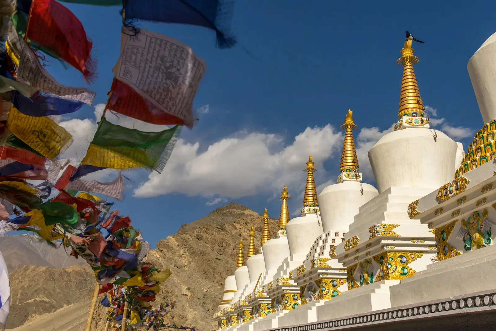 A yellow and red Buddhist monastery building set against the blue sky of Ladakh