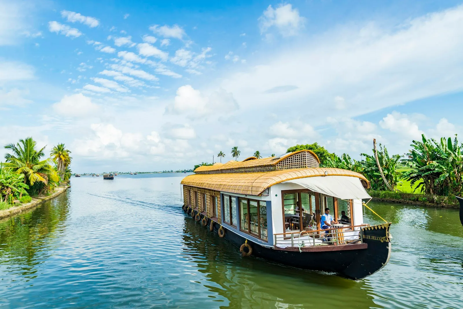 A traditional wooden houseboat drifting through the still backwaters of Alleppey, Kerala