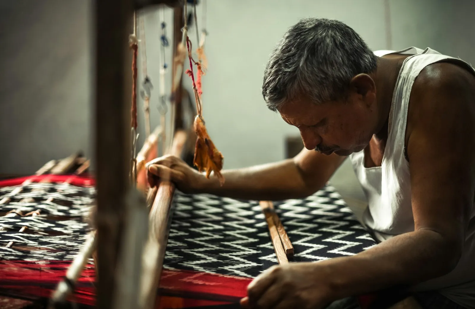 A weaver working grey silk on a traditional handloom in Pochampally, Telangana