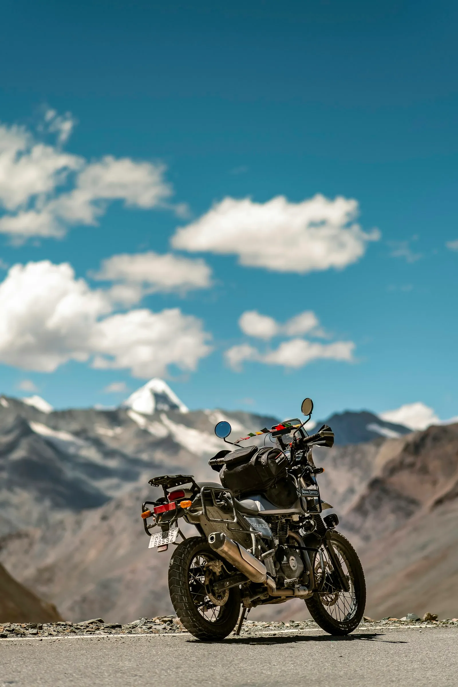 A Royal Enfield motorcycle parked on a mountain road in Leh, Ladakh